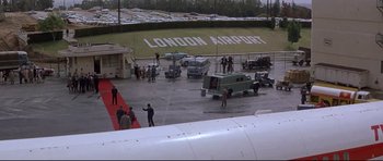 Movie still from “The Lost World” (1960), directed by Irwin Allen – A group of people standing next to an airplane; Extreme Wide shot, High angle
