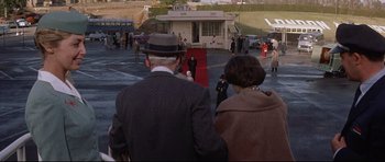 Movie still from “The Lost World” (1960), directed by Irwin Allen – A man and a woman are standing in a parking lot; Wide shot, High angle