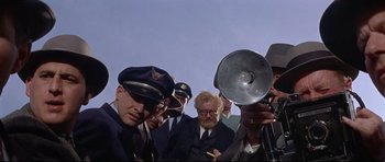 Movie still from “The Lost World” (1960), directed by Irwin Allen – A group of men standing next to each other; Medium shot, Low angle