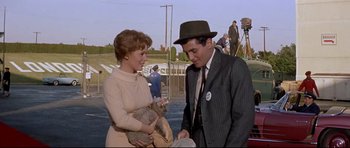 Movie still from “The Lost World” (1960), directed by Irwin Allen – A man and a woman are holding a koala; Medium shot, Over the shoulder angle