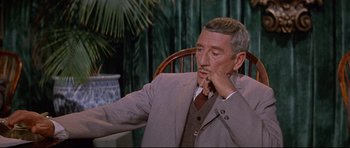 Movie still from “The Lost World” (1960), directed by Irwin Allen – A person wearing a suit and tie; Close Up shot, High angle