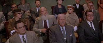 Movie still from “The Lost World” (1960), directed by Irwin Allen – A group of people sitting in a room; Medium shot, High angle