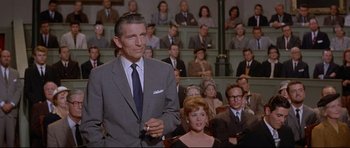 Movie still from “The Lost World” (1960), directed by Irwin Allen – A man standing in front of an audience in front of a crowd; Medium shot, Low angle