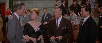 Movie still from “The Lost World” (1960), directed by Irwin Allen – A man and a woman standing next to each other in a courtroom; Medium shot, Low angle