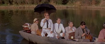 Movie still from “The Lost World” (1960), directed by Irwin Allen – A group of men sitting in a boat on a river; Wide shot, High angle