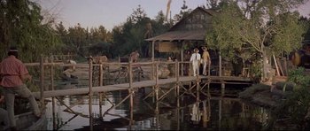 Movie still from “The Lost World” (1960), directed by Irwin Allen – A group of people standing on a wooden pier; Extreme Wide shot, Low angle