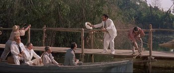 Movie still from “The Lost World” (1960), directed by Irwin Allen – A man on a boat throwing a frisbee to another man on a boat; Wide shot, High angle