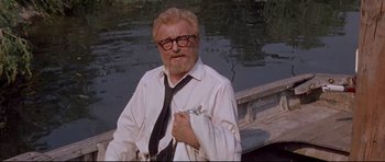 Movie still from “The Lost World” (1960), directed by Irwin Allen – An older man with a beard wearing glasses and a white shirt; Medium shot, Low angle