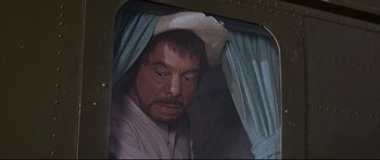 Movie still from “The Lost World” (1960), directed by Irwin Allen – A person wearing a hat; Close Up shot, Over the shoulder angle