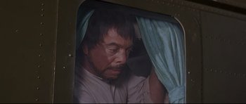 Movie still from “The Lost World” (1960), directed by Irwin Allen – A person with a curtain over their head; Medium shot, Over the shoulder angle