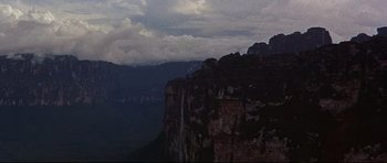 Movie still from “The Lost World” (1960), directed by Irwin Allen – A view of a mountain range with a waterfall in the distance; Extreme Wide shot, High angle