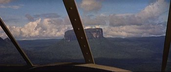 Movie still from “The Lost World” (1960), directed by Irwin Allen – A view of a mountain from a plane window; Extreme Wide shot, High angle