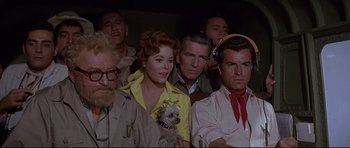 Movie still from “The Lost World” (1960), directed by Irwin Allen – A group of men and a woman with a small dog; Medium shot, High angle