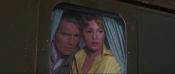 Movie still from “The Lost World” (1960), directed by Irwin Allen – A man and a woman standing next to each other in front of a window; Close Up shot, Low angle