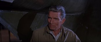 Movie still from “The Lost World” (1960), directed by Irwin Allen – An older man in a brown jacket looking at the camera; Close Up shot, High angle