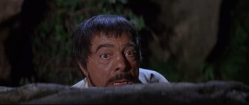 Movie still from “The Lost World” (1960), directed by Irwin Allen – A man with a beard and mustache looking at the camera; Close Up shot, Low angle