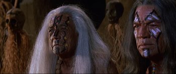 Movie still from “The Lost World” (1960), directed by Irwin Allen – A man with white hair is standing next to another man with white hair; Close Up shot, Over the shoulder angle