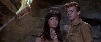 Movie still from “The Lost World” (1960), directed by Irwin Allen – A man and a woman standing next to each other; Close Up shot, Low angle