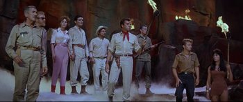 Movie still from “The Lost World” (1960), directed by Irwin Allen – A group of men standing next to each other holding a torch; Wide shot, Low angle