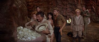 Movie still from “The Lost World” (1960), directed by Irwin Allen – A group of people standing in a cave; Medium shot, High angle