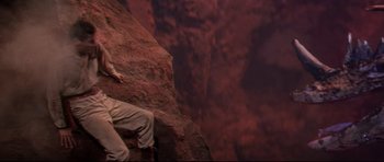 Movie still from “The Lost World” (1960), directed by Irwin Allen – A man climbing a rock wall on top of a mountain; Wide shot, Overhead angle