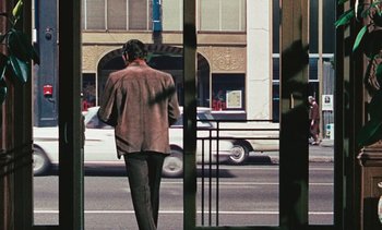 Movie still from “The Love Bug” (1969), directed by Robert Stevenson – A man walking down the street while talking on a cell phone; Wide shot, Over the shoulder angle