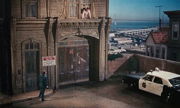 Movie still from “The Love Bug” (1969), directed by Robert Stevenson – A man standing in front of an old building; Extreme Wide shot, High angle