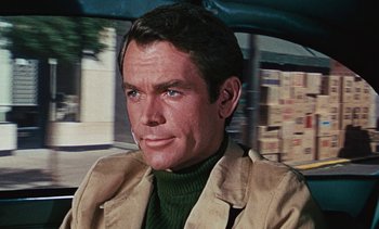 Movie still from “The Love Bug” (1969), directed by Robert Stevenson – A person sitting in a car on the street; Close Up shot, Over the shoulder angle
