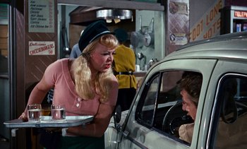 Movie still from “The Love Bug” (1969), directed by Robert Stevenson – A woman in a hat is talking to a man in a car; Medium shot, Over the shoulder angle