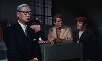 Movie still from “The Love Bug” (1969), directed by Robert Stevenson – A group of men standing next to each other in a room; Medium shot, Over the shoulder angle