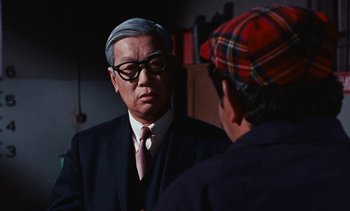 Movie still from “The Love Bug” (1969), directed by Robert Stevenson – A man wearing a suit and tie talking to another man; Close Up shot, Over the shoulder angle