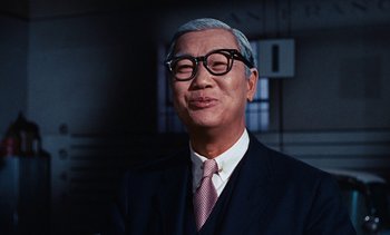 Movie still from “The Love Bug” (1969), directed by Robert Stevenson – An older man wearing a suit and tie; Close Up shot, Over the shoulder angle