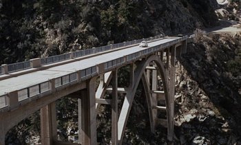 Movie still from “The Love Bug” (1969), directed by Robert Stevenson – A car is driving on a bridge over a river; Extreme Wide shot, High angle