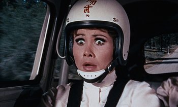 Movie still from “The Love Bug” (1969), directed by Robert Stevenson – A woman wearing a helmet in a car; Close Up shot, Low angle