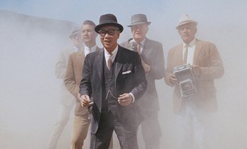 Movie still from “The Love Bug” (1969), directed by Robert Stevenson – A group of men in suits and hats holding a camera; Medium shot, Low angle
