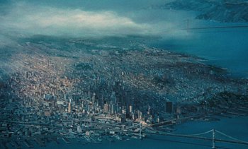 Movie still from “The Love Bug” (1969), directed by Robert Stevenson – An aerial view of a large city with a bridge in the background; Extreme Wide shot, High angle