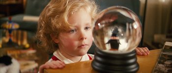 Movie still from “The Lovely Bones” (2009), directed by Peter Jackson – A young child looking at a snow globe; Close Up shot, Over the shoulder angle