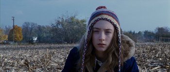 Movie still from “The Lovely Bones” (2009), directed by Peter Jackson – A young girl wearing a hat in a field; Close Up shot, Over the shoulder angle