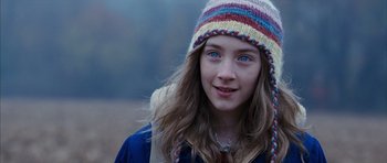 Movie still from “The Lovely Bones” (2009), directed by Peter Jackson – A young girl with blue eyes wearing a colorful hat; Close Up shot, Over the shoulder angle