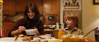 Movie still from “The Lovely Bones” (2009), directed by Peter Jackson – Two people sitting at a table with food; Medium shot, Over the shoulder angle
