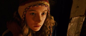 Movie still from “The Lovely Bones” (2009), directed by Peter Jackson – A young girl wearing a colorful hat looking at the camera; Close Up shot, High angle