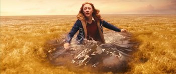 Movie still from “The Lovely Bones” (2009), directed by Peter Jackson – A woman is running through the water in a field; Wide shot, High angle