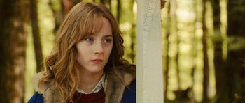 Movie still from “The Lovely Bones” (2009), directed by Peter Jackson – A young woman with a fur coat is leaning against a pole; Close Up shot, Over the shoulder angle