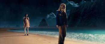 Movie still from “The Lovely Bones” (2009), directed by Peter Jackson – A woman standing on the beach in front of the ocean; Wide shot, High angle