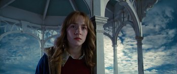 Movie still from “The Lovely Bones” (2009), directed by Peter Jackson – A woman standing next to a pillar with clouds in the background; Close Up shot, Low angle