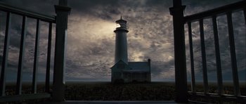 Movie still from “The Lovely Bones” (2009), directed by Peter Jackson – A light house is shown against a cloudy sky; Extreme Wide shot, Low angle