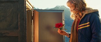 Movie still from “The Lovely Bones” (2009), directed by Peter Jackson – A woman holding a red rose in front of mountains; Medium shot, Low angle
