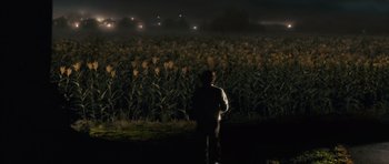 Movie still from “The Lovely Bones” (2009), directed by Peter Jackson – A man standing in front of a corn field at night; Extreme Wide shot, High angle