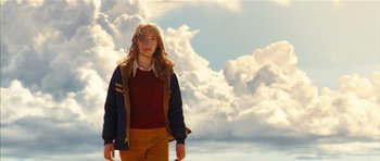 Movie still from “The Lovely Bones” (2009), directed by Peter Jackson – A woman standing in front of a cloud filled sky; Medium shot, Low angle