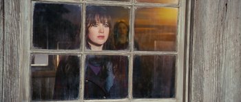 Movie still from “The Lovely Bones” (2009), directed by Peter Jackson – A woman looking out of a window at the sunset; Medium shot, Over the shoulder angle